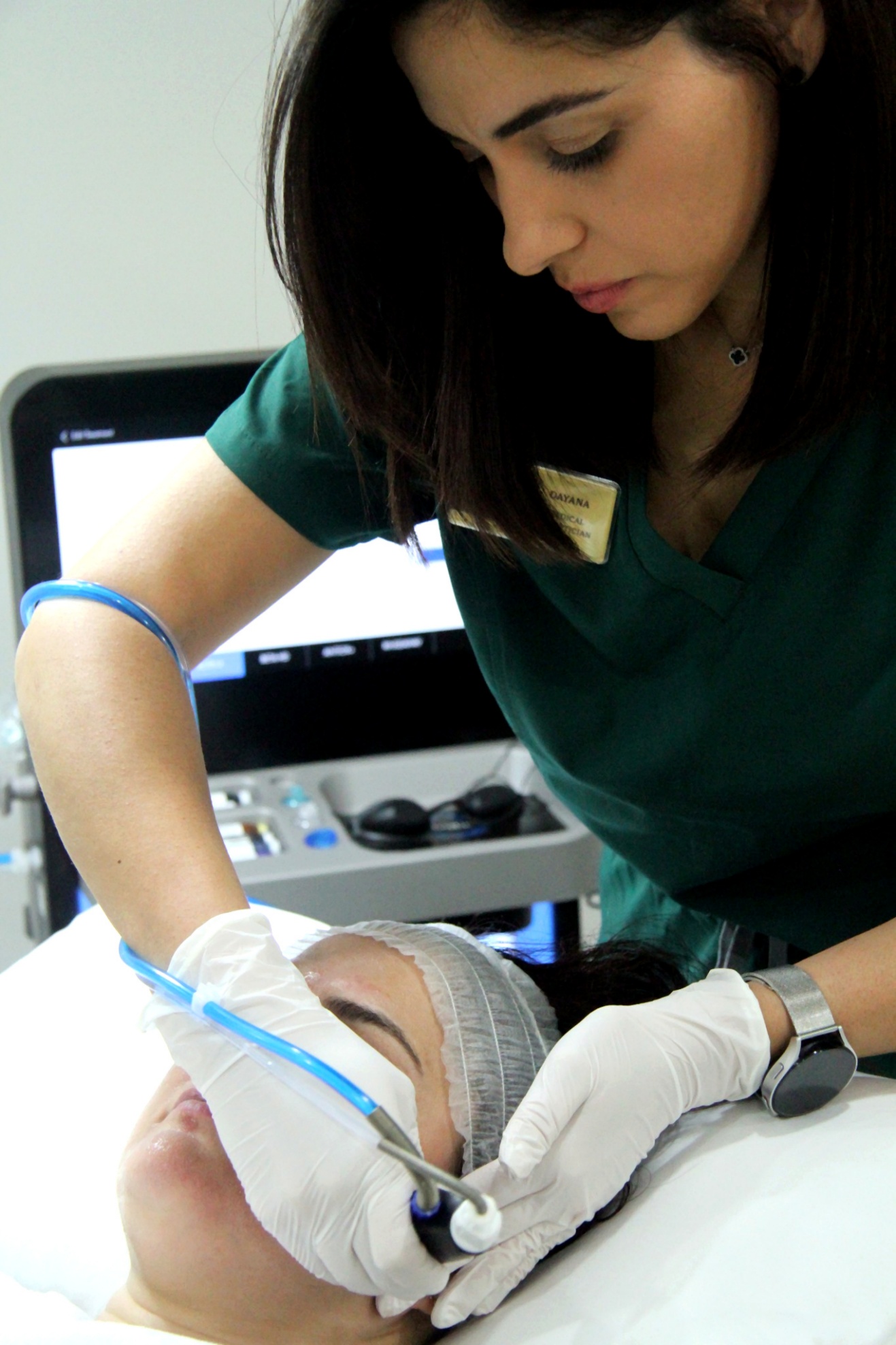A practitioner performing a HydraFacial treatment for a client
